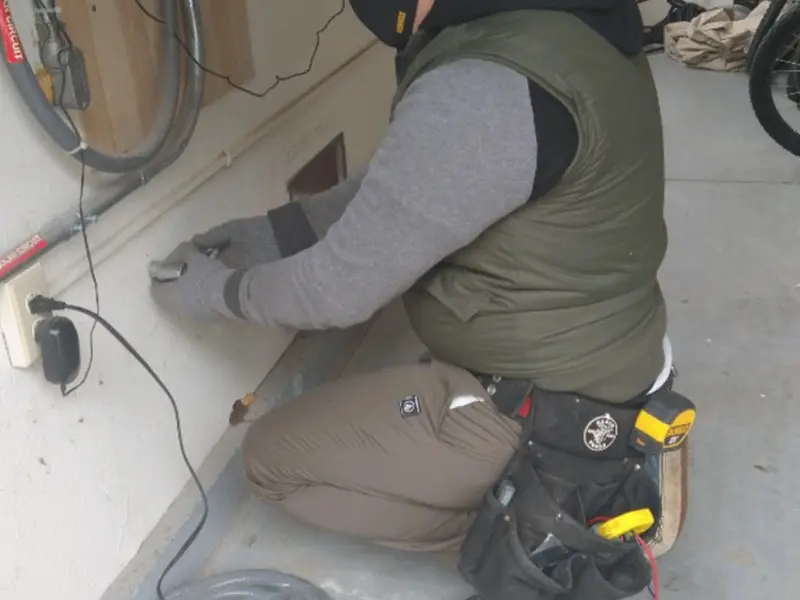 Electrician performing outlet wiring in a Mount Laurel garage